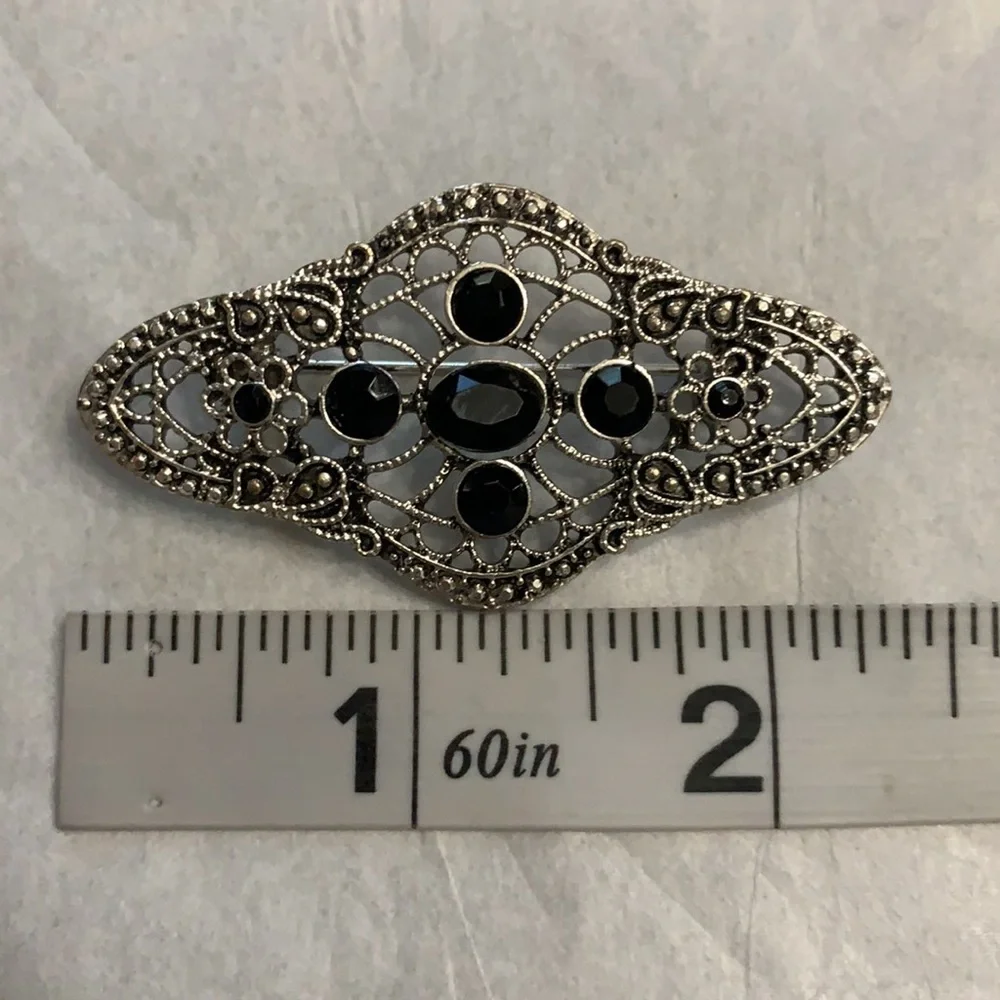 Silver and black brooch